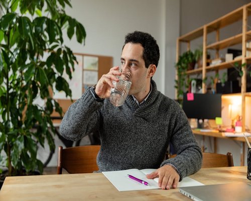 Person drinking water at work desk